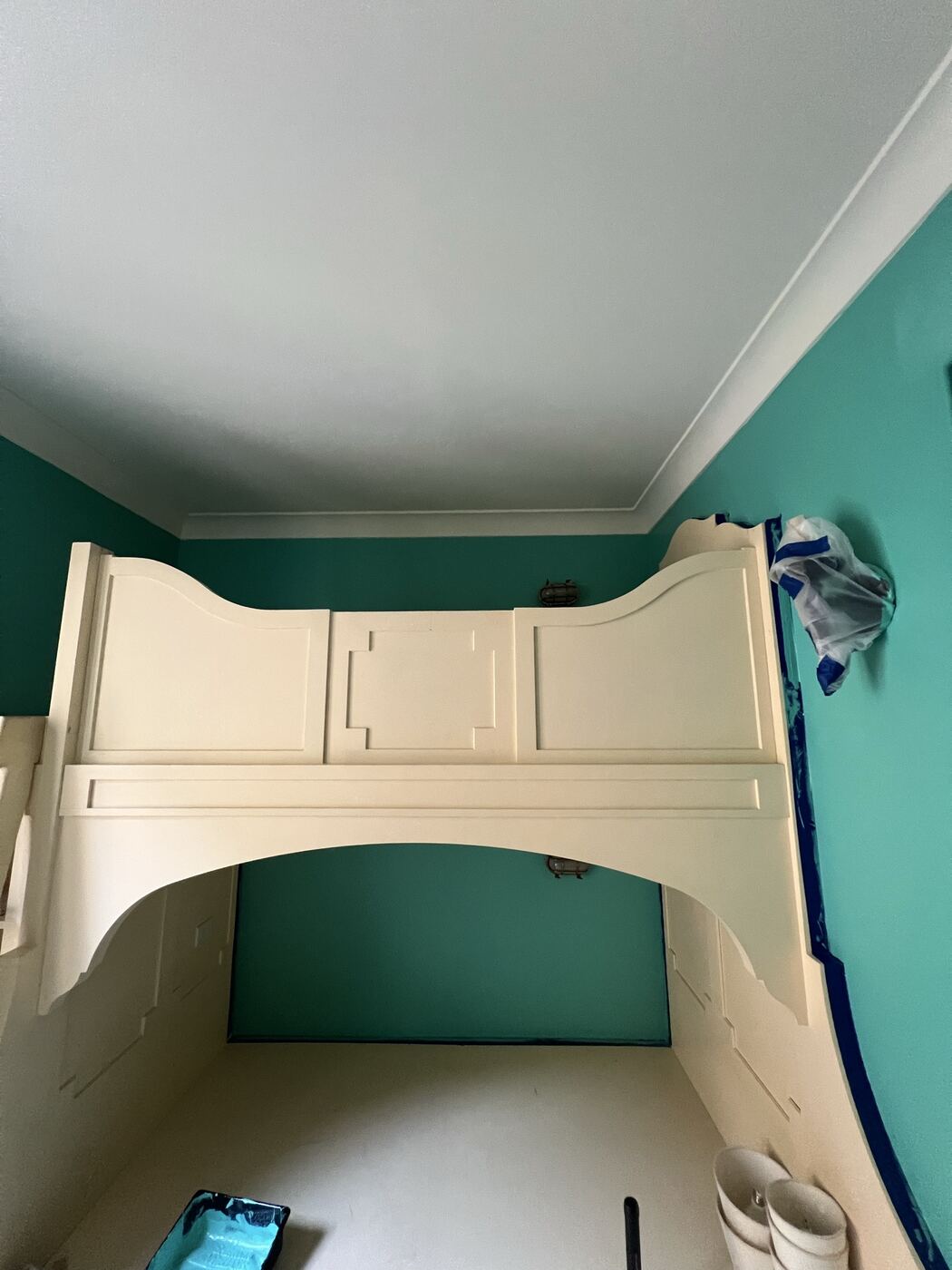 Finished built-in mantle and hood painted crisp white against a teal accent wall