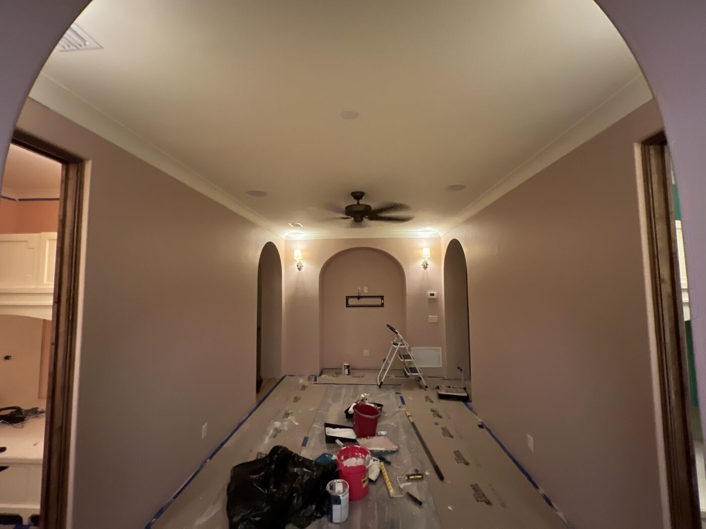 Hallway prepped for painting with drop cloths, tape, and supplies