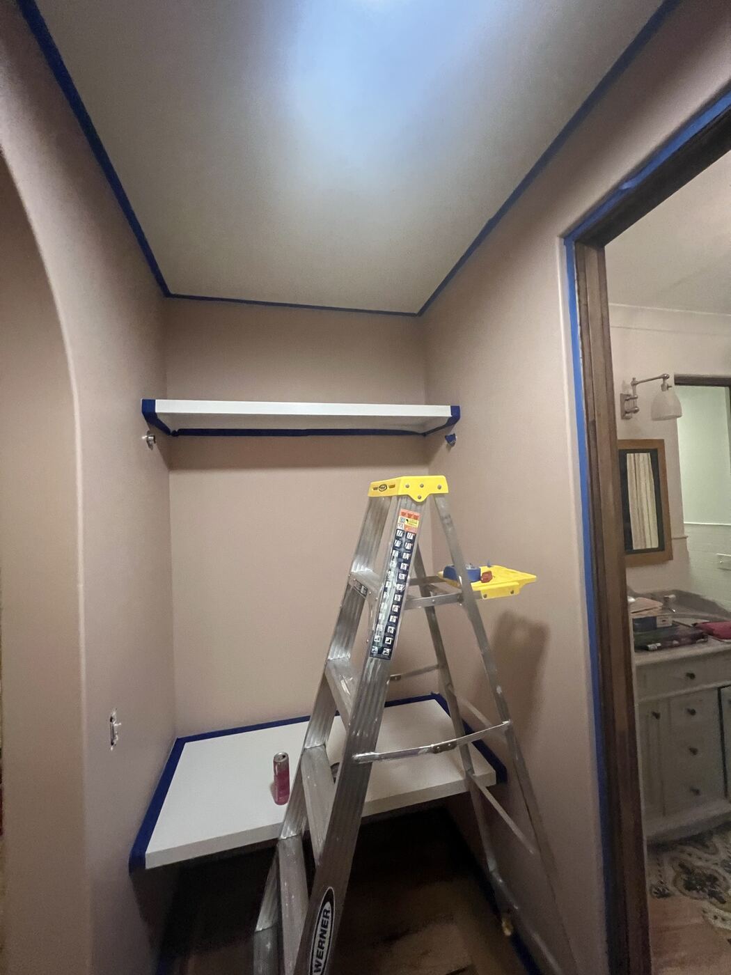 Closet being painted, shelving taped off mid-project