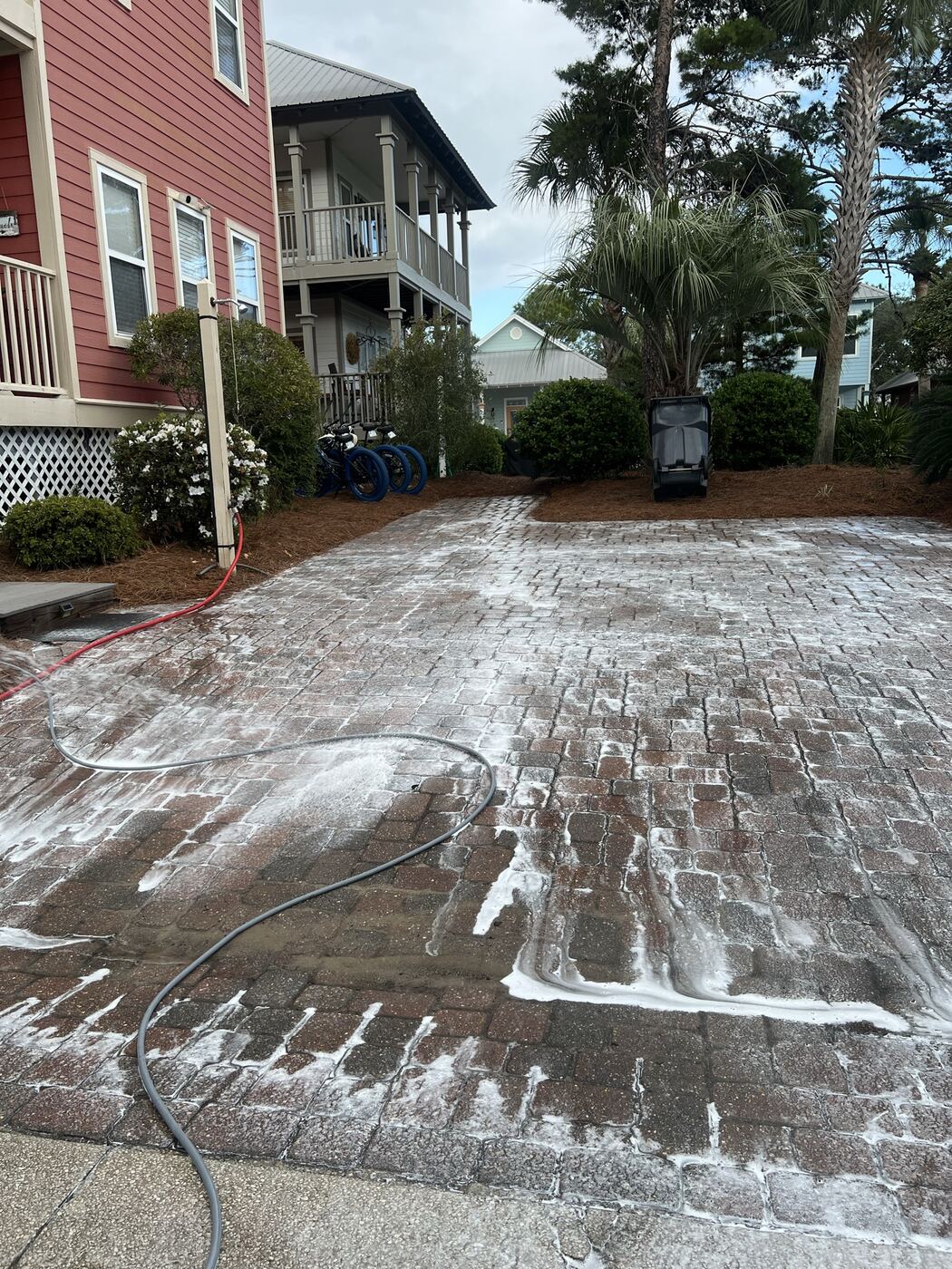 Pressure washing cleaner solution being applied to a brick paver driveway