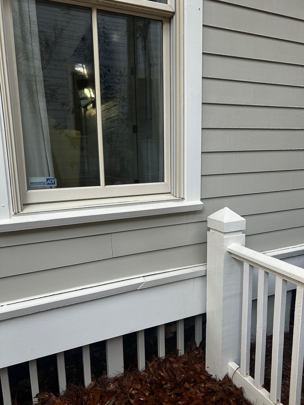 Close-up of window sill and siding before cleaning, with black mold and mildew streaking